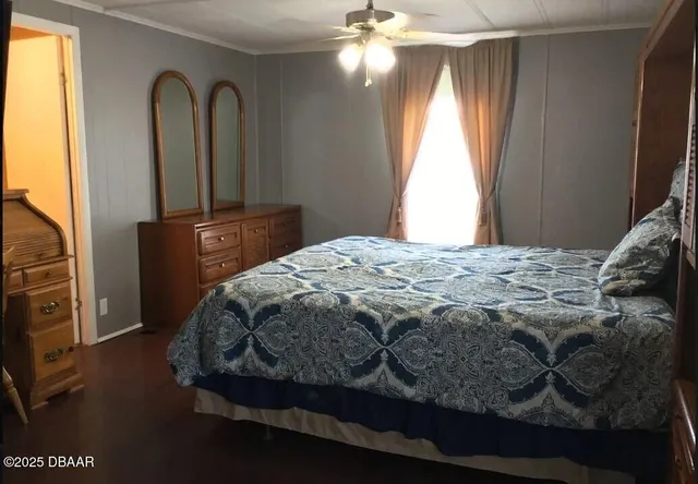 a bedroom with a bed and a flat tv screen on dresser