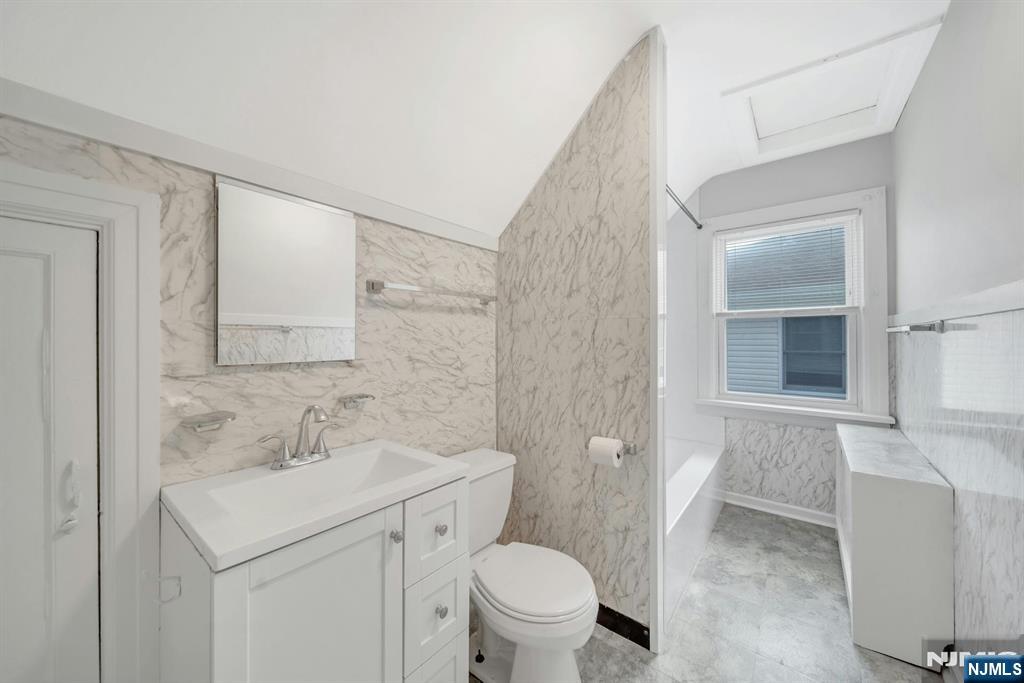 88 McKinley Avenue, Unit 2 Lodi, NJ 07644 - Photo 8 of 10 a bathroom with a sink toilet and vanity