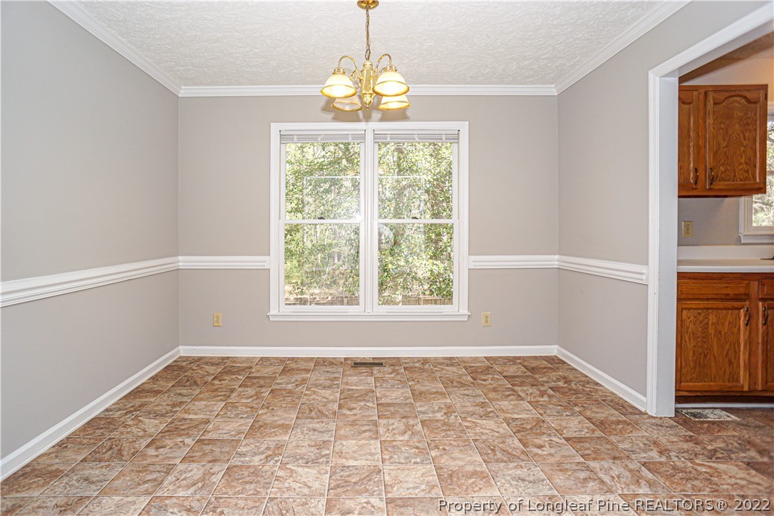 5094 Summer Ridge Road Fayetteville, NC 28303 - Photo 8 of 30 an empty room with windows and chandelier