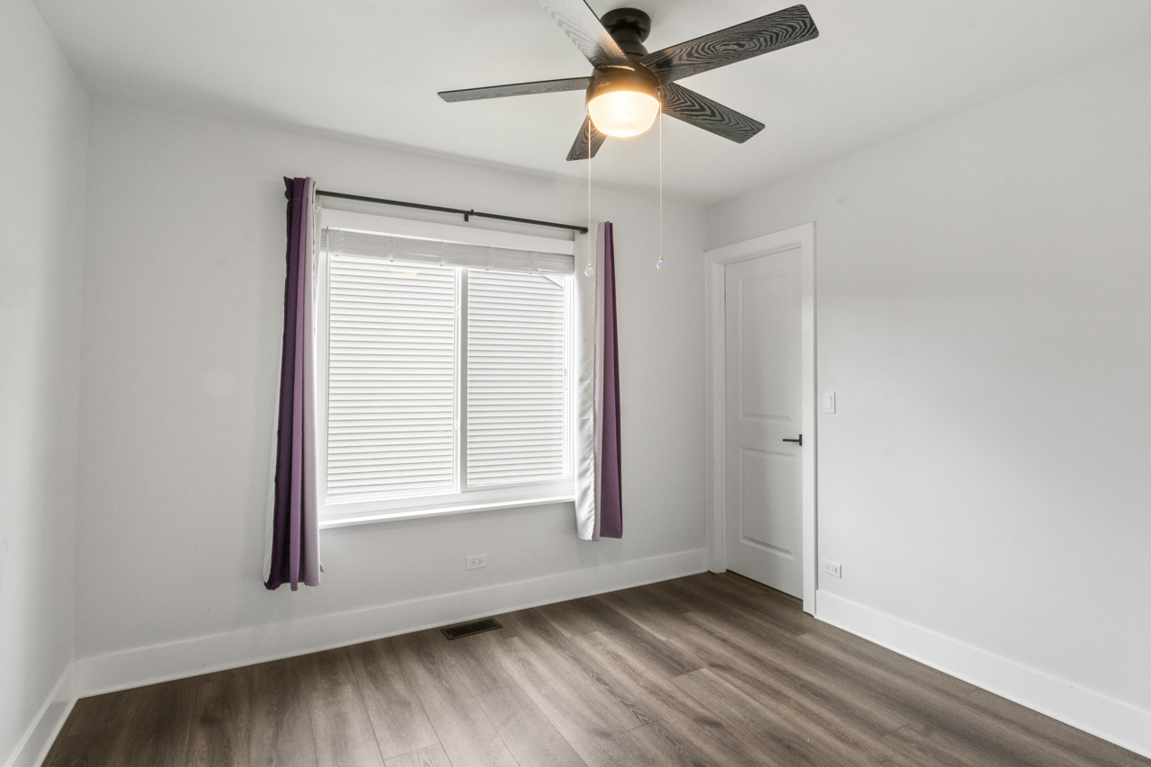 25782 West Prairieview Road Round Lake, IL 60073 - Photo 21 of 34 an empty room with wooden floor ceiling fan and windows