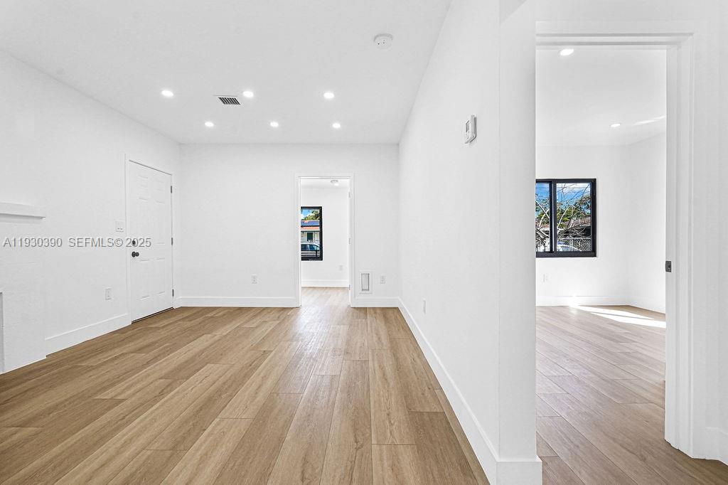 3040 Northwest 13th Avenue Miami, FL 33142 - Photo 27 of 46 an empty room with wooden floor and windows
