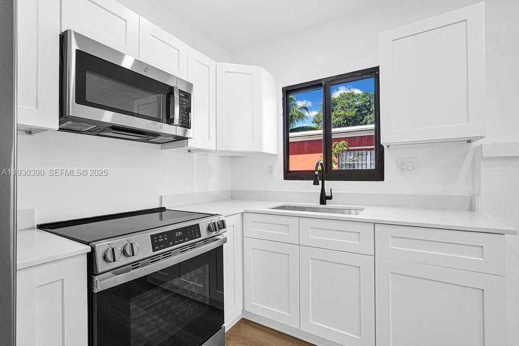 3040 Northwest 13th Avenue Miami, FL 33142 - Photo 28 of 46 a kitchen with a sink stove and microwave