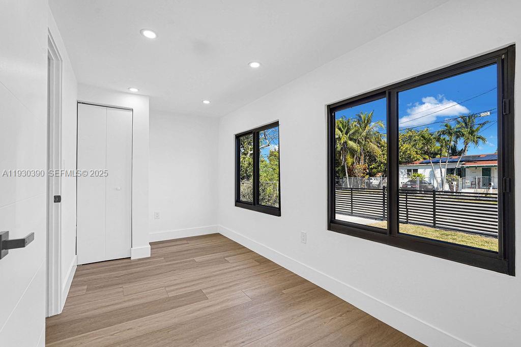 3040 Northwest 13th Avenue Miami, FL 33142 - Photo 34 of 46 a view of an empty room with wooden floor and a window