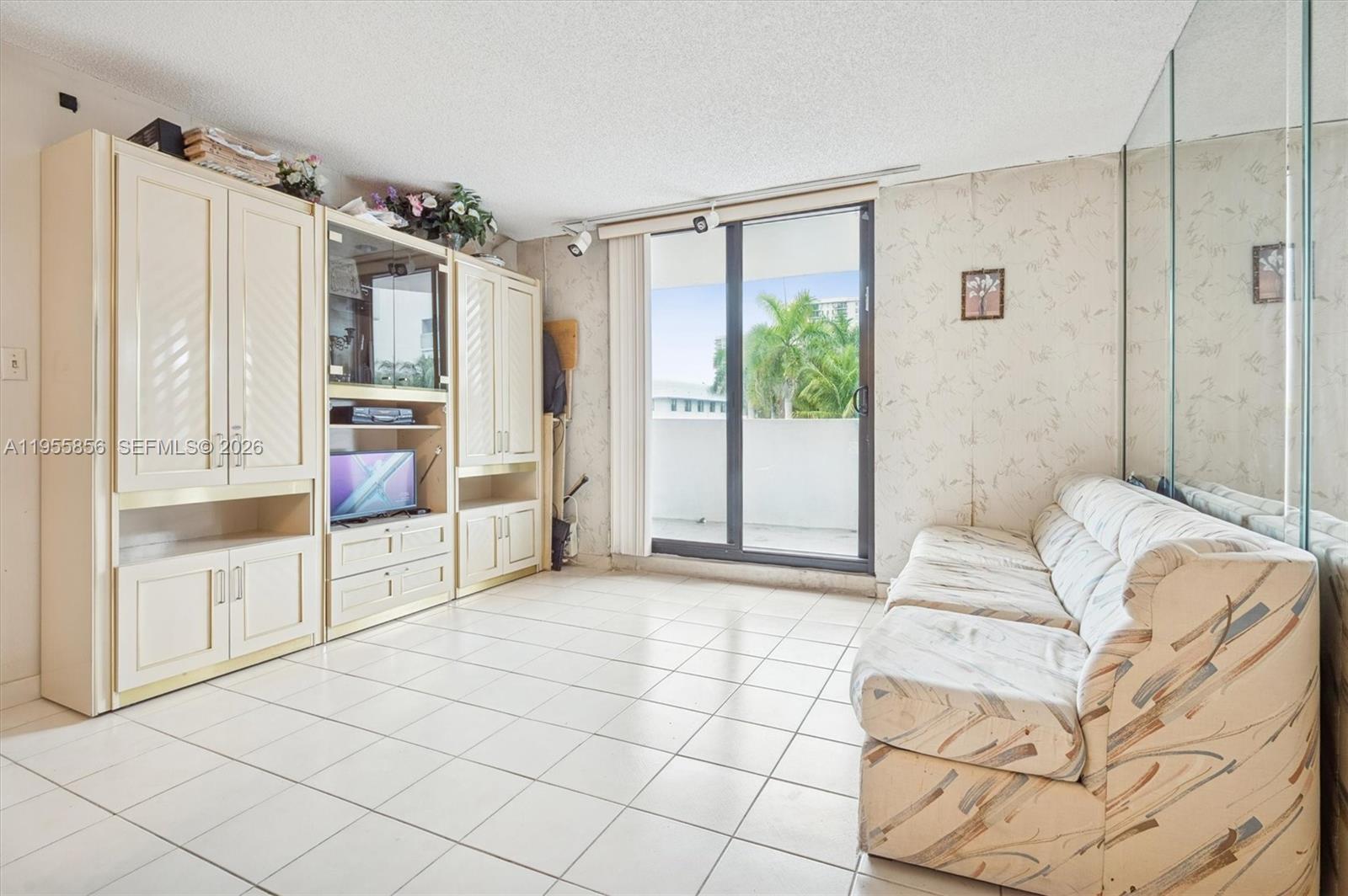 4301 Collins Avenue, Unit 202 Miami Beach, FL 33140 - Photo 3 of 12 a living room with furniture and a chandelier