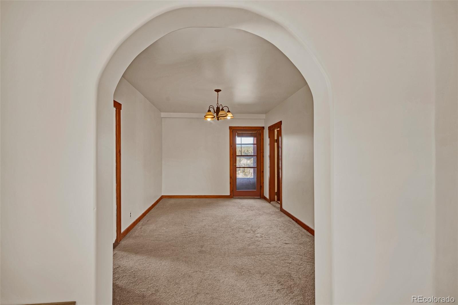 711 Front Street Fairplay, CO 80440 - Photo 15 of 40 an empty room with a hallway and chandelier