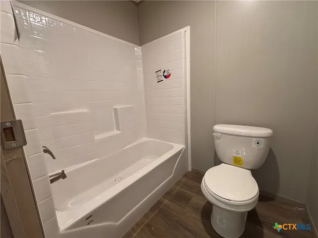 a white toilet sitting next to a bath tub