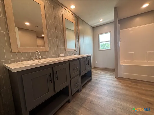 a bathroom with a double vanity sink and a mirror