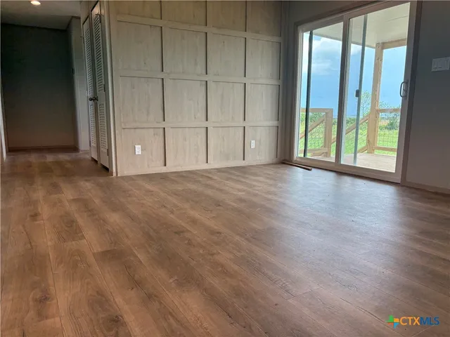 an empty room with wooden floor and sliding door