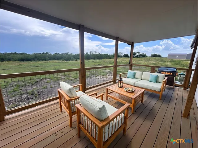 a view of a roof deck with couches and wooden floor
