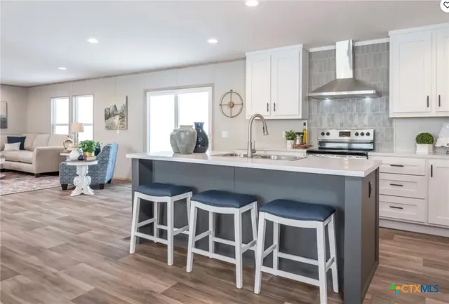 a kitchen with granite countertop a sink cabinets and wooden floor