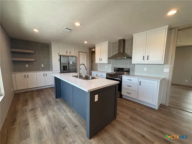 a kitchen with kitchen island granite countertop a sink counter top space and cabinets