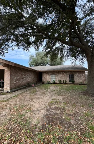 a backyard of a house with large trees and wooden fence