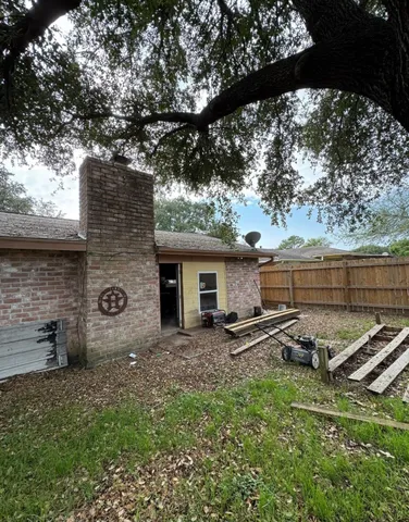 a view of a backyard with table and chairs and a large tree