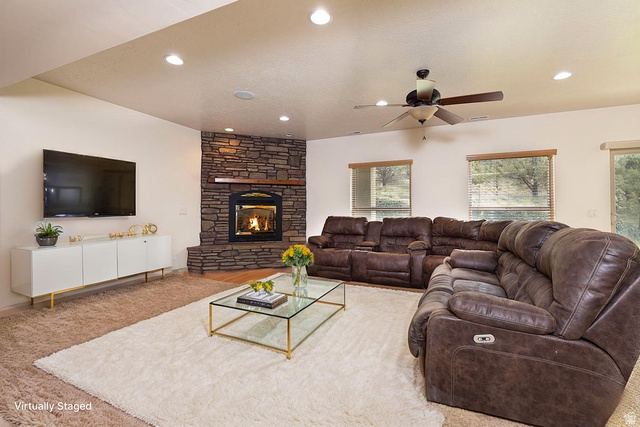 888 East Fiddlers Canyon Road Cedar City, UT 84721 - Photo 41 of 74 Carpeted living area with ceiling fan, a stone fireplace, and recessed lighting