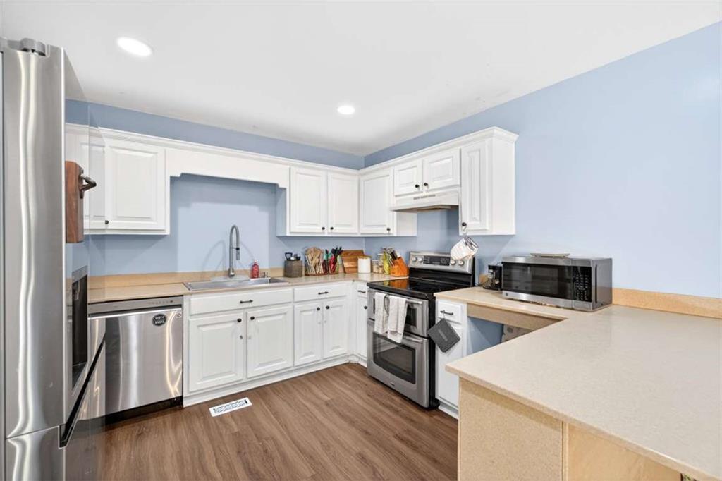 386 Ridgewood Drive Pendergrass, GA 30567 - Photo 13 of 50 a kitchen with stainless steel appliances white cabinets and wooden floors