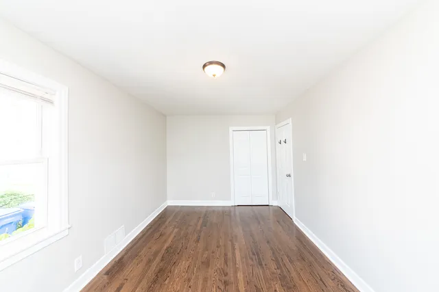 a view of a room with wooden floor and white walls