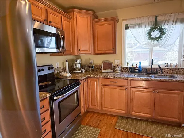 a kitchen with stainless steel appliances a stove a sink and a microwave