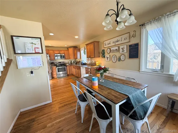 a view of a dining room with furniture a chandelier and wooden floor