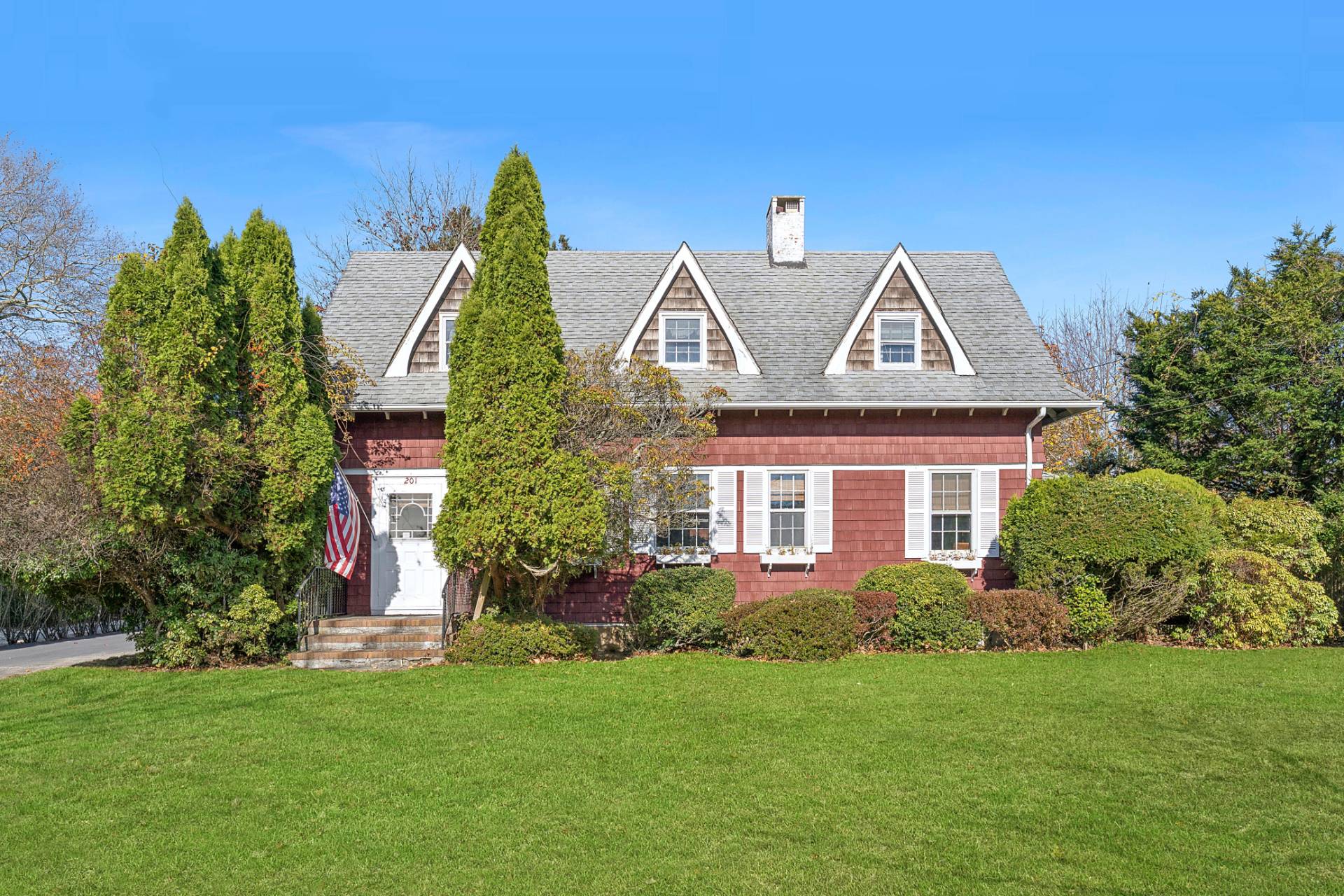 201 Herrick Road Southampton, NY 11968 - Photo 1 of 29 a front view of a house with a garden