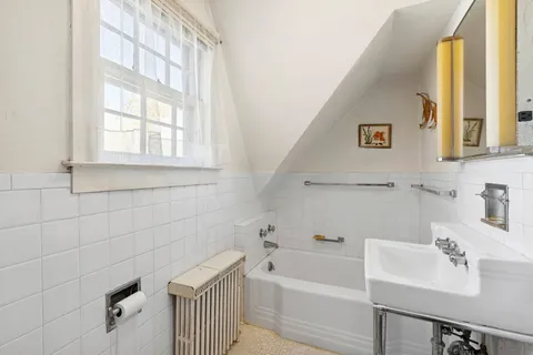 a bathroom with a sink a bathtub and a window