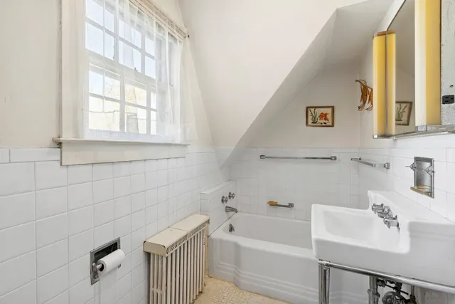 a bathroom with a sink a bathtub and a window