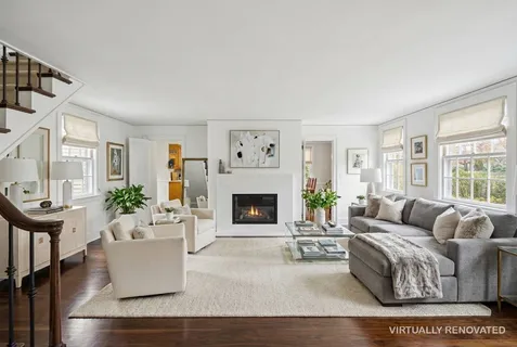 a living room with furniture a fireplace and a large window