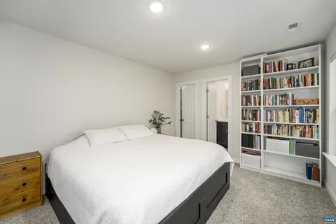 a large bed sitting in a bedroom and a bookshelf