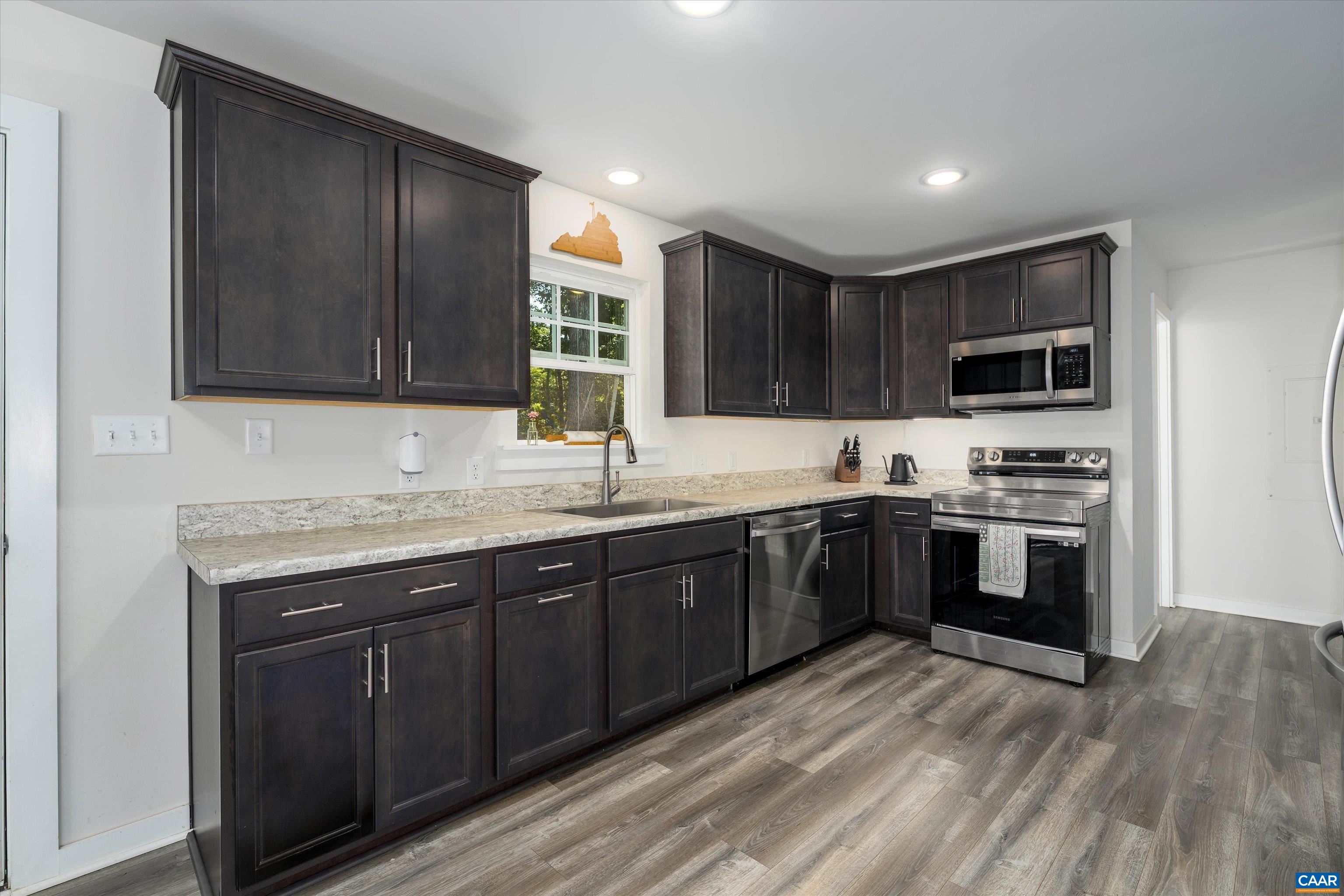 6 Kingswood Road Palmyra, VA 22963 - Photo 5 of 41 a kitchen with granite countertop wooden cabinets a stove top oven and stainless steel appliances