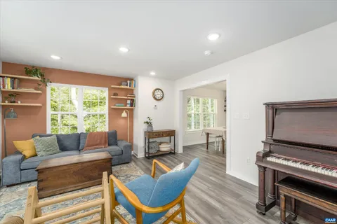 a living room with furniture a flat screen tv and a large window