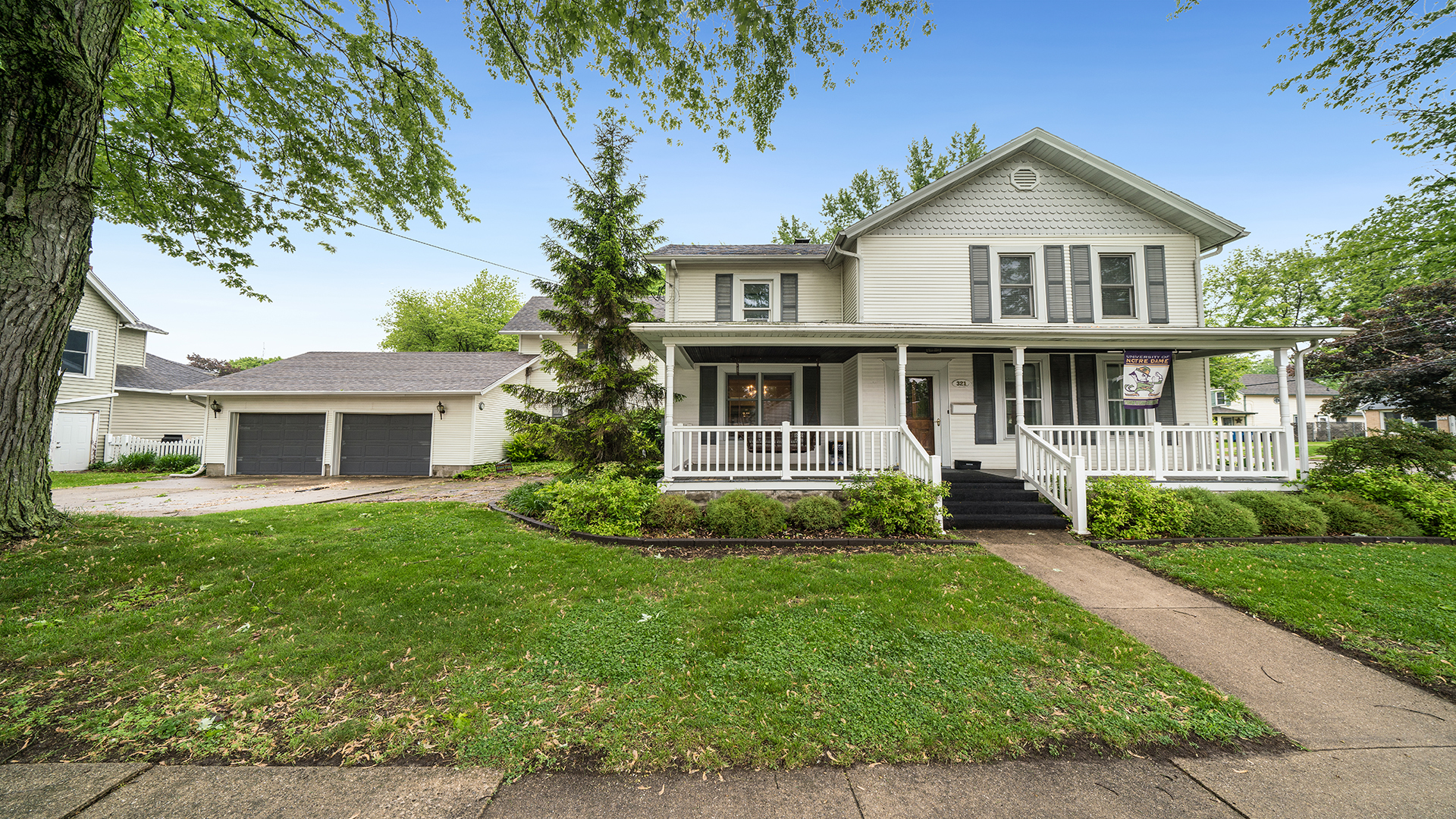 a view of a house with a yard and potted plants