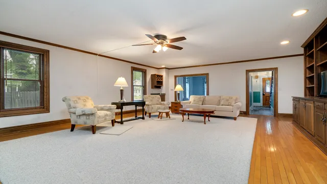 a living room with fireplace furniture and a large window
