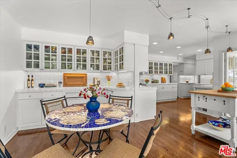a dining room with furniture a kitchen view and chandelier