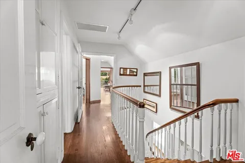a view of a hallway with wooden floor and stairs