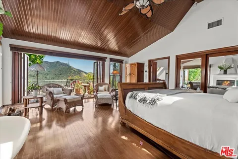 a bed sitting in a spacious bedroom next to a large window