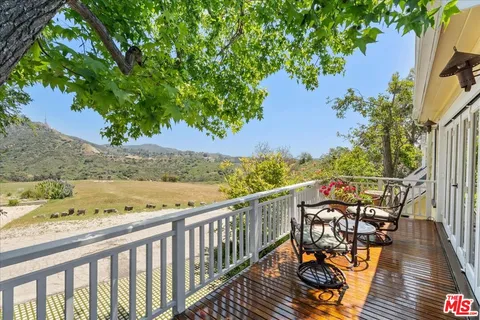 a view of balcony with wooden floor and outdoor seating