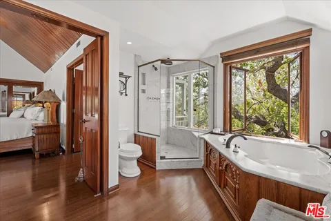 a spacious bathroom with a tub shower and toilet