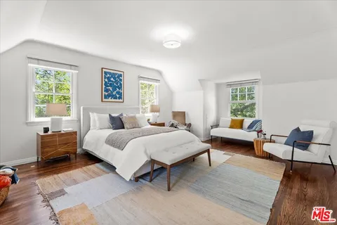 a spacious bedroom with a bed a couch and a window