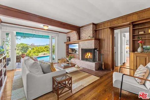 a living room with furniture fireplace and a large window