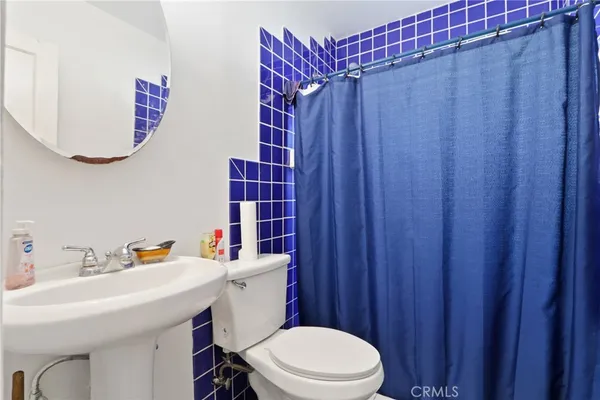 a bathroom with a sink a toilet and shower curtain