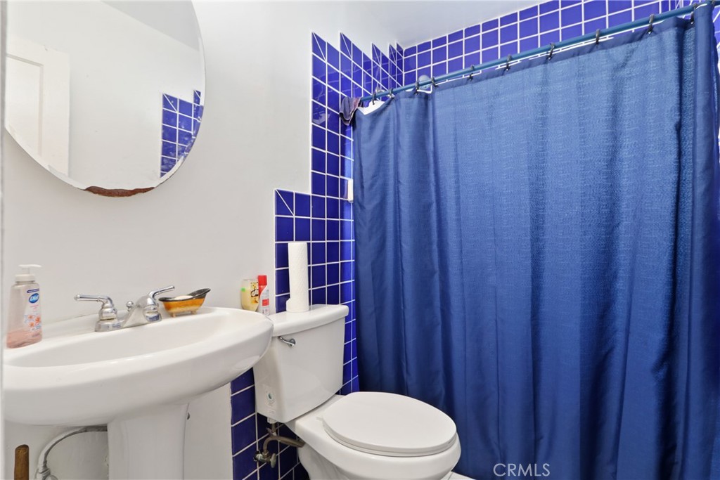 229 East Reeve Street Compton, CA 90220 - Photo 7 of 11 a bathroom with a sink a toilet and shower curtain