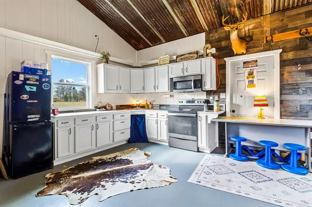 a kitchen with stainless steel appliances granite countertop a sink a stove and cabinets