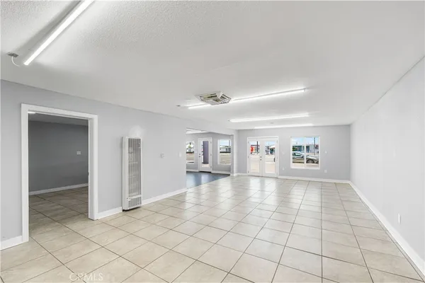 a view of empty room with wooden floor and windows