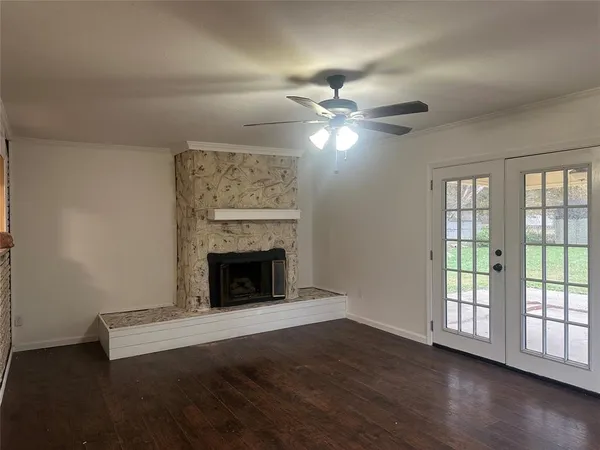 wooden floor fireplace and windows in an empty room