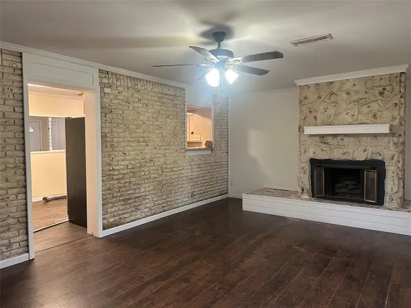 a view of a livingroom with wooden floor a ceiling fan and window