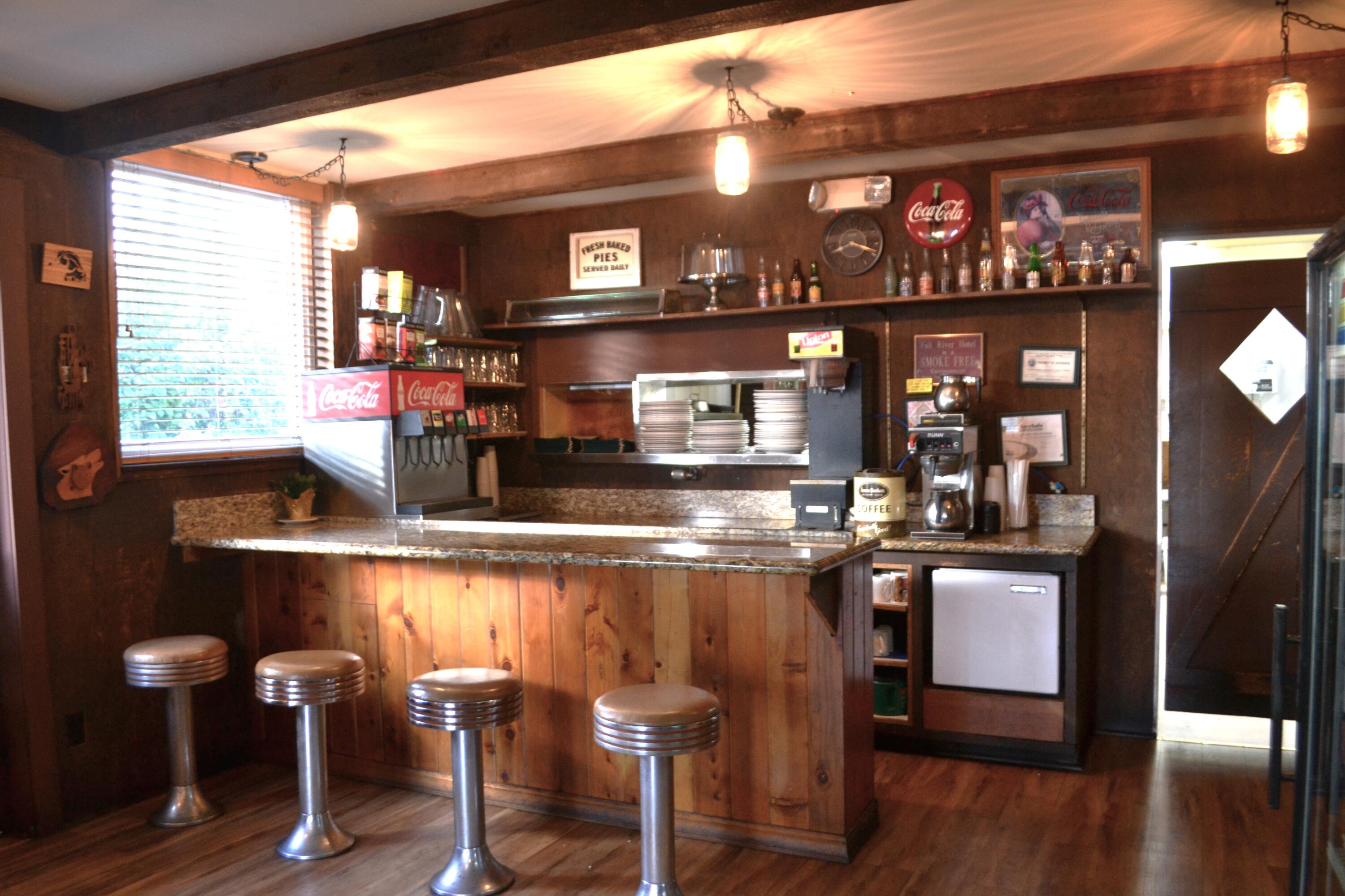 24860 Main Street Fall River Mills, CA 96028 - Photo 17 of 50 a kitchen with stainless steel appliances granite countertop a table chairs in it and wooden floors