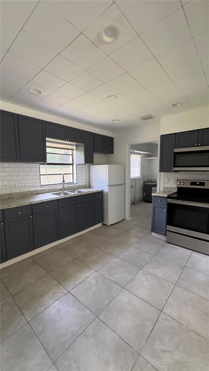 2008 North 47th Street Fort Pierce, FL 34947 - Photo 3 of 27 a large kitchen with kitchen island granite countertop a stove a sink and a microwave
