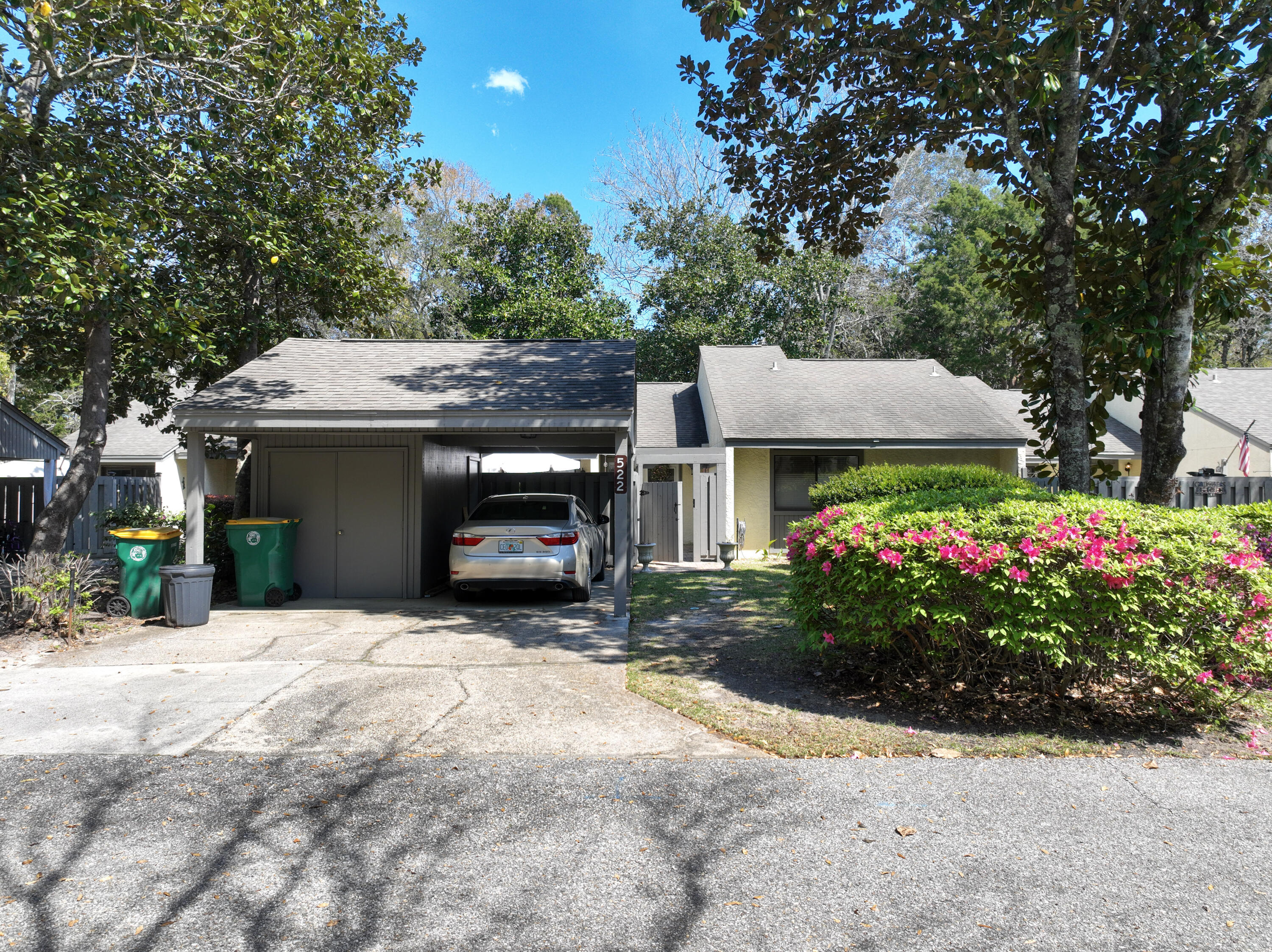 a view of a house with potted plants and a large tree