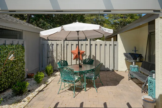a patio with a table and chairs under an umbrella