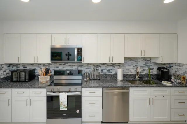 a kitchen with appliances a sink and cabinets