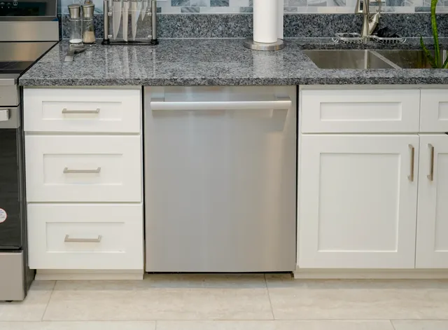 a kitchen with granite countertop cabinets and white appliances